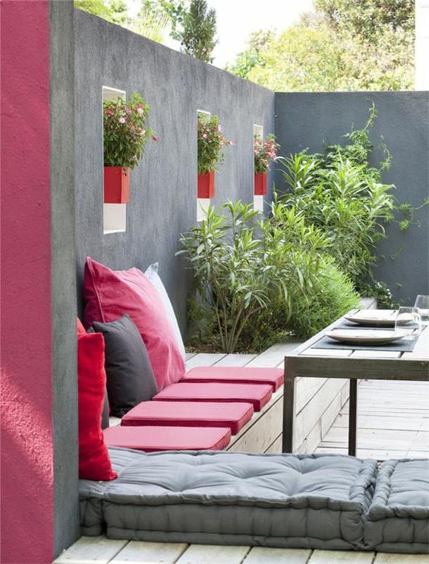 škrlatna barva na pokriti terasi z zunanjim pohištvom in sivimi stenami