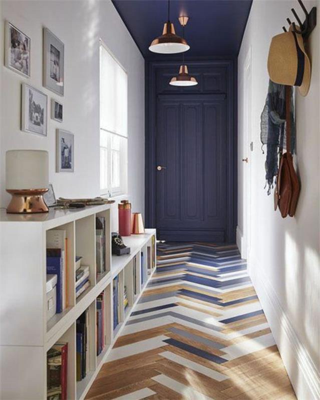 koridoriaus apdaila su ančių mėlynais dažais, durys ir lubos mėlynos ančių spalvos, parketo grindys išdėstytos asimetriškai, nudažytos mėlyna, balta ir pilka spalvomis, kailio kablys ant sienos baltose, baltose dėžutėse kaip sandėliavimo patalpos, baltas ir bronzinis apšvietimas, penki paveikslai su baltais rėmeliais , du bronzos spalvos žibintai