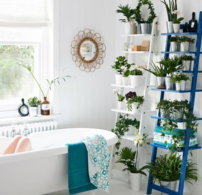 atspalvio kambarinis augalas, žalias vonios kambarys, baltos tamsiai mėlynos kopėčios ir kopėčios, veidrodis su austu pintų gėlių rėmu, balta vonia, baltos plytelės