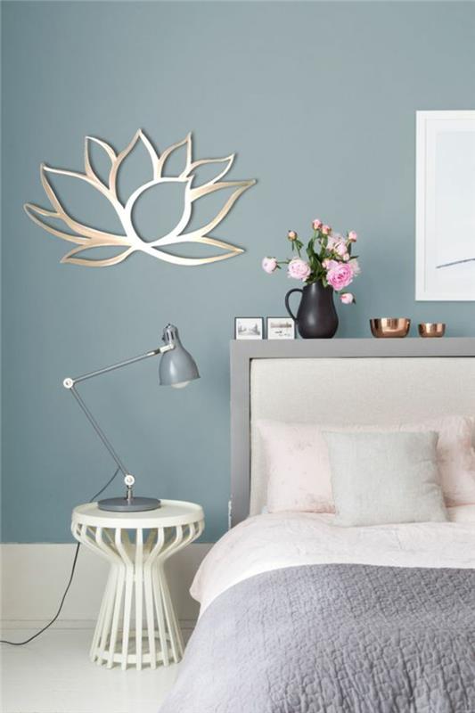 modri odtenek na steni nad posteljo v spalnici za odrasle v modro sivi in ​​beli barvi