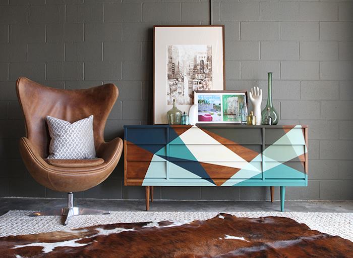 Paprasta deko svetainė, rudos odos fotelis, mediniai spintelės dažai, medinės spintos pertvarkymas, spalvinga geometrinė spintelės tapybos idėja