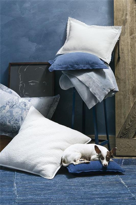 cijan modri sobni kotiček v boemskem slogu z velikimi blazinami v beli, modri in svetlo sivi barvi