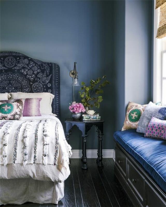 modra dekoracija spalnice za odrasle z veliko posteljo v naslonu za hrček in klopjo za shranjevanje z kraljevsko modrimi blazinami in barvnimi blazinami