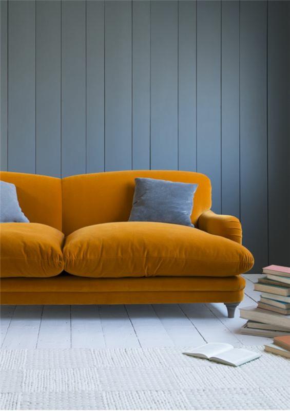 azurno modra siva barva na steni, oblečeni v les, pobarvan v modro sivo barvo z velikim mehkim kavčem v vitaminsko oranžnem žametu
