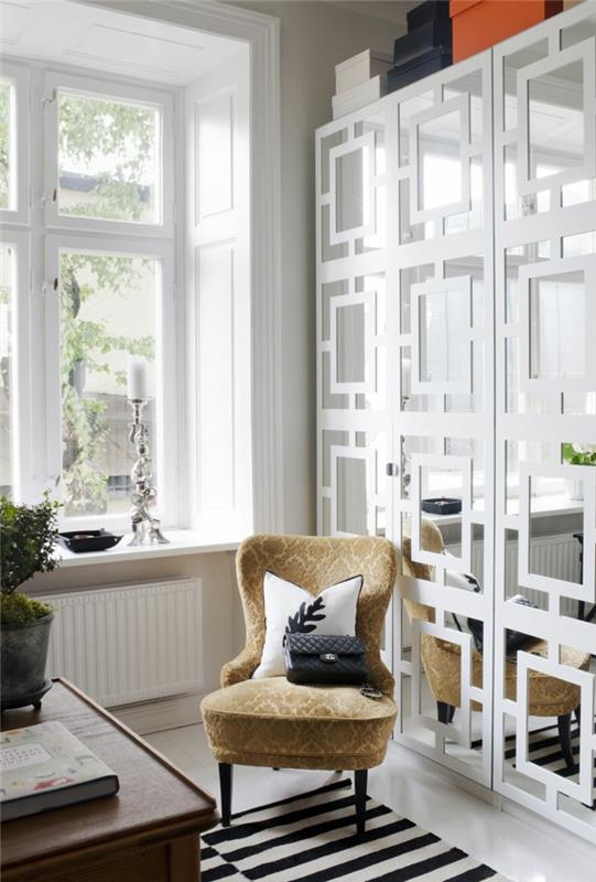 1-alinea-dekoratyvinis-veidrodis-gyvenamajame kambaryje-smėlio spalvos-kėdė-langas-gyvenamajame kambaryje