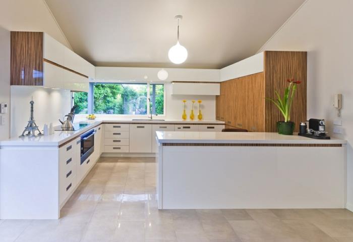 1 balta virtuvė su smėlio spalvos plytelėmis išklotais baldais-suolais ir nuožulniomis lubomis