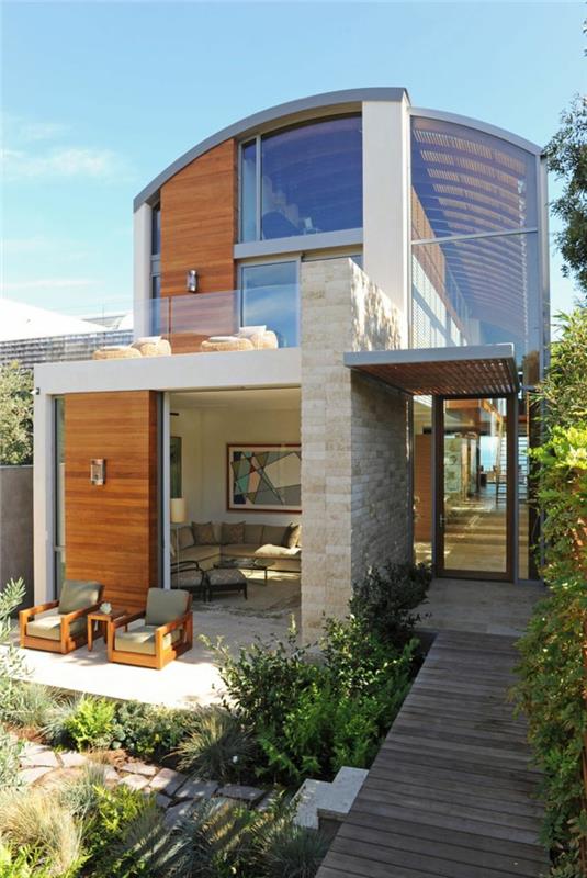 1-gana minimalistinio stiliaus namo išorė akmenyje ir dideliuose languose