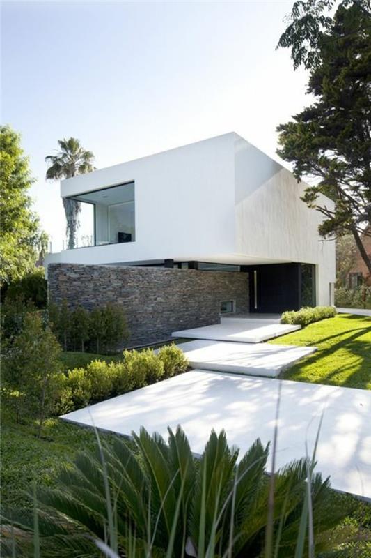 1-minimalizmas architektūroje-gana šiuolaikiškas namas su žalia veja ir gana minimalistiniu sodu