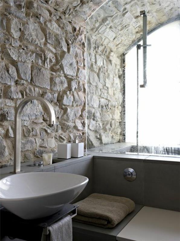 1 retro vonios kambarys su atvira akmens siena ir pilka vonia