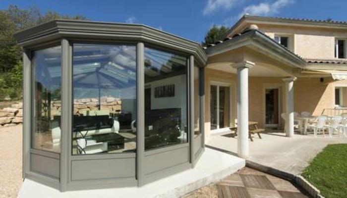 Šiuolaikinė aliuminio veranda, kuri yra kontrastinga su gretimu namu