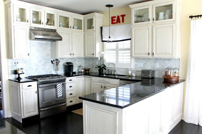 2 baltai lakuota virtuvė su juodais purslais baltos spalvos mediniais baldais