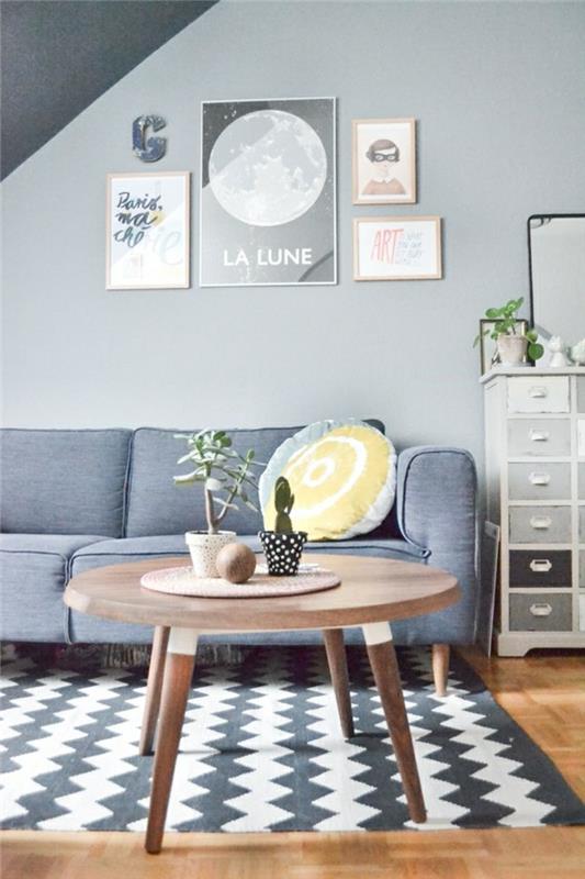 2 šviesiai pilkos spalvos interjeras ir pilkas kilimas gyvenamajame kambaryje su apvaliu geriamuoju kavos stalu