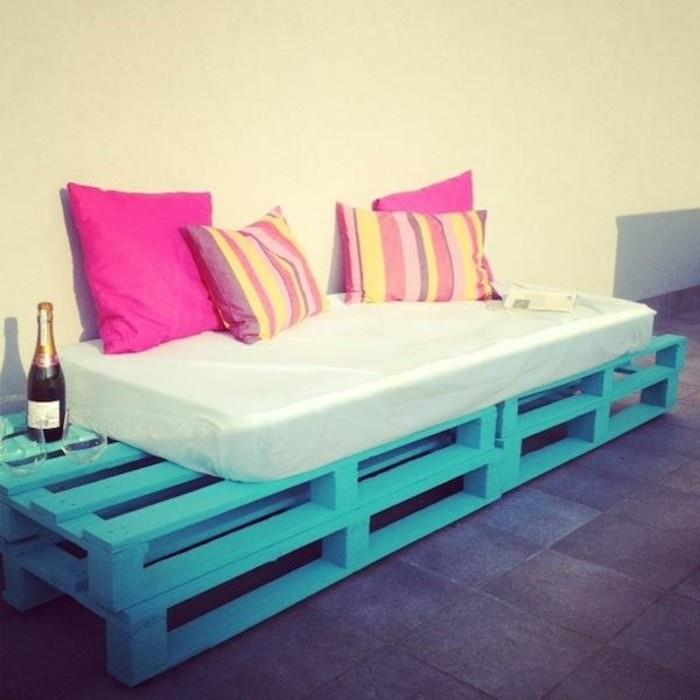 Arredamento terrazzo con divano bancali, dipinto colore blu, decorazioni con cuscini colorati
