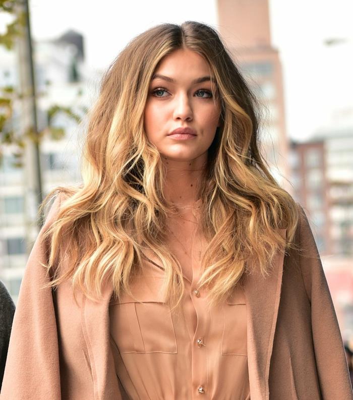 bakır kravat ve boya, GIgi Hadid, uzun saç, hafif dalgalı vurgular, kahverengi bir taban üzerinde karamel balyaj