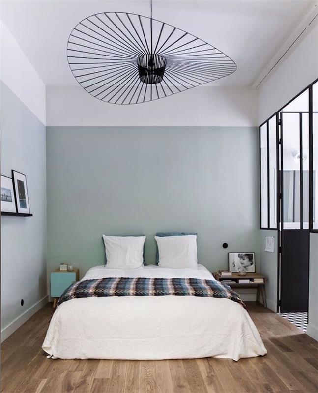 podstrešje s spalnico za odrasle s preprosto in moderno dekoracijo, sivo zelena barva sten, oblikovan lestenec iz kovine