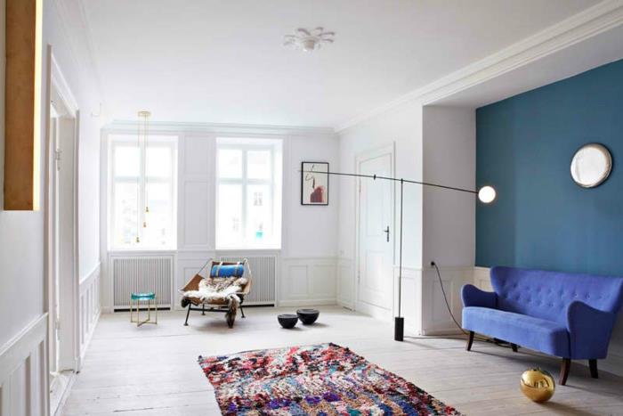 Dnevna soba-opremljena-s-pisanimi-preprogami-idejami-kavčem-v modri barvi