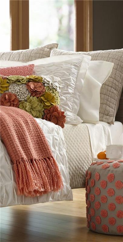 posteljna odeja marelične barve, siv stolček z rožnatimi pikami, koralno rožnate in bele blazine
