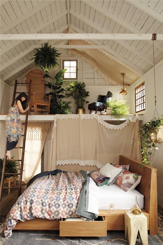 primer boemske dekoracije v studiu z visokim stropom z lesenim pohištvom in zelenimi eksotičnimi rastlinami