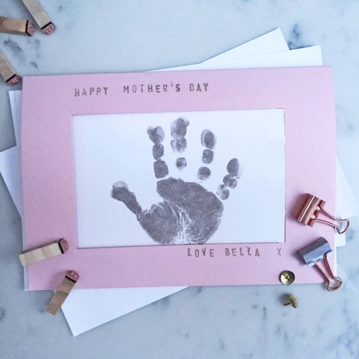 lengvai pagaminama motinos dienos dovana, baltos kortelės šablonas su juodu vaikišku atspaudu ir rožiniu popieriniu rėmeliu