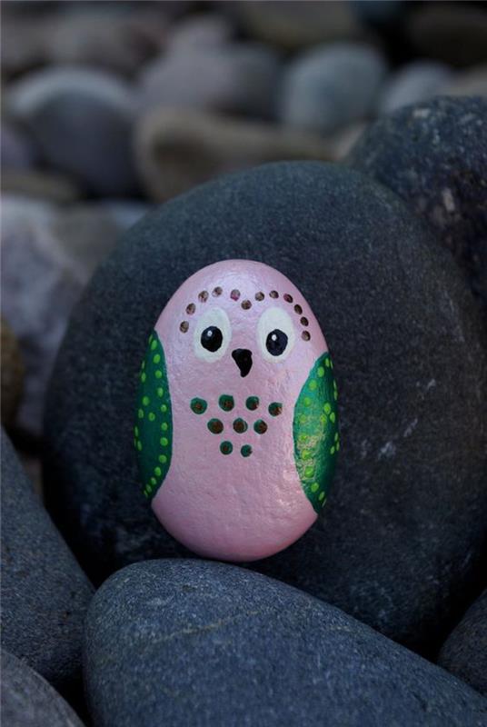 sova v roza in zeleni barvi narejena na okrasnem kamenčku, ideja za DIY otroka polnega domišljije