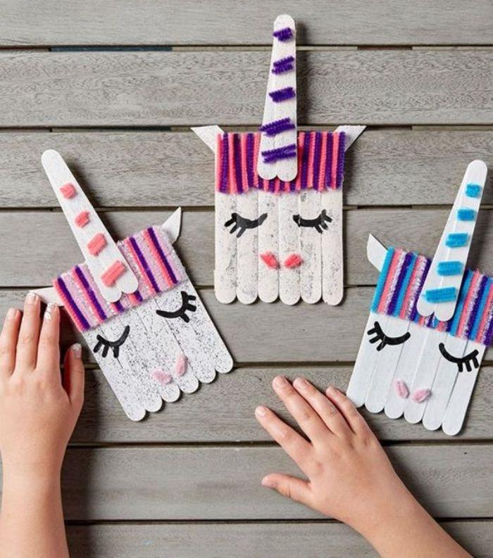 dondurma çubuklarıyla etkinlik, tek boynuzlu at oyuncağı yapmak için çubuklar, yün iplikler ve payetler kullanan 4 yaşındaki bir çocuk etkinliği örneği