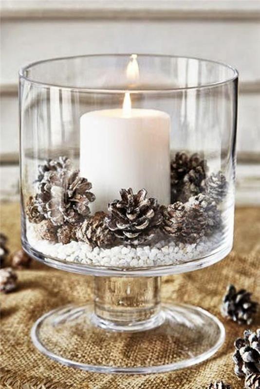 Božični okras, da se naredite v veliki stekleni skledi z veliko belo svečo in navadnimi borovimi storži, majhnimi belimi kamenčki na dnu sklede