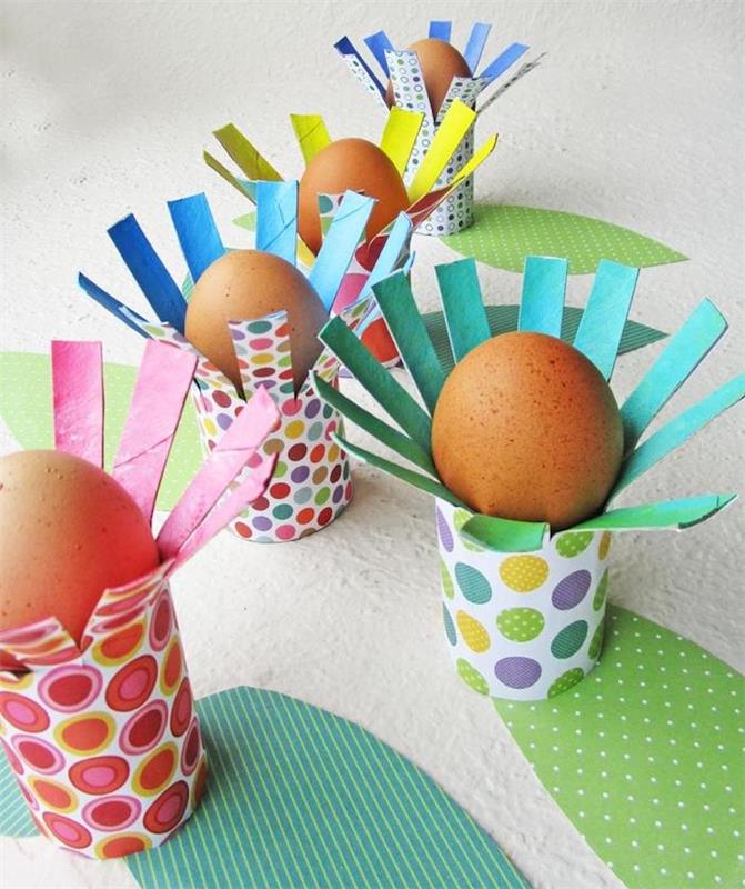 Držala za velikonočna jajca iz recikliranega toaletnega papirja, zavita v barvit vesel papir z vzorci