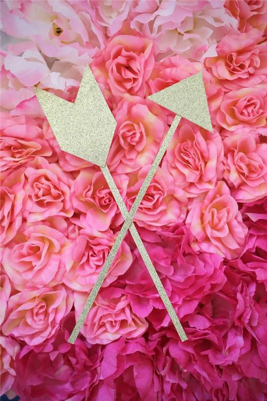 sevgililer günü manuel etkinliği iki ahşap ok ve sahte güller üzerine parlak kağıt