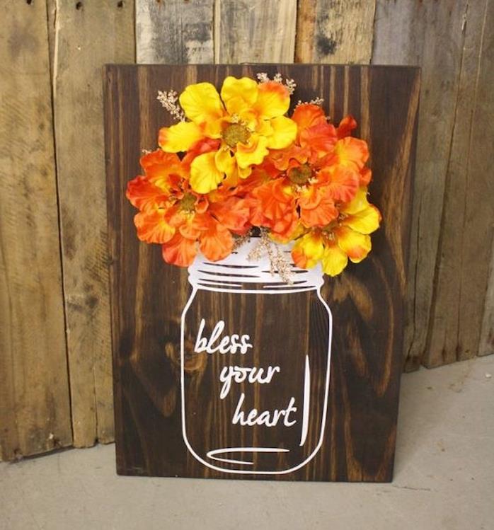 rjava lesena deska z lončnico, bela vaza iz klobučevine in šopek rumenega in oranžnega cvetja, jesenski dekor, ki ga naredite sami
