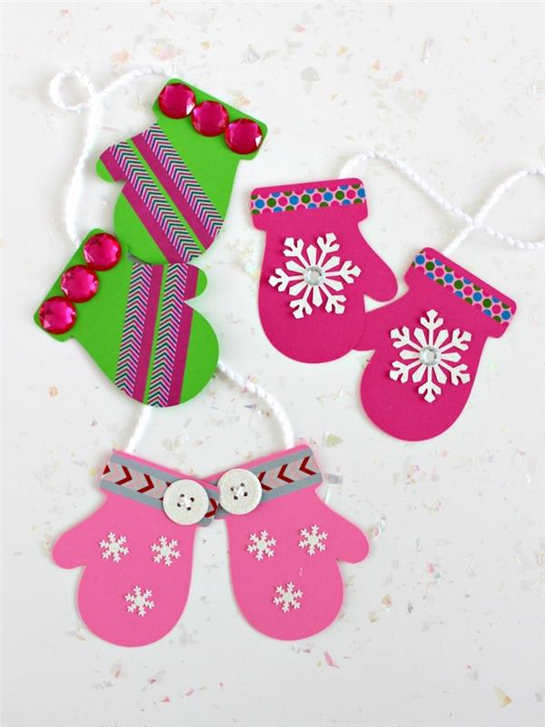 Kart stoğundan kesilmiş ve maskeleme bandı ve düğmelerle süslenmiş eldiven çiftleri, çocuklarla yapılacak Noel el işleri