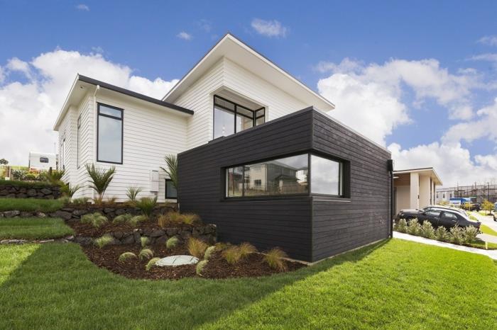 Šauni balto ir juodo namo idėja, kaip papuošti fasadą, išorines medines dailylentes, žalią vejos važiuojamąją dalį pastatytą automobilį