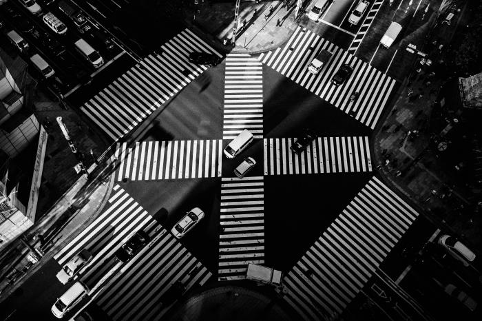 črno -bela fotografija velikega prehoda v Tokiu, gledano od zgoraj z belimi črtami talnih oznak, fotografija mestne krajine