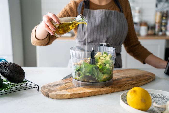 olivno olje vlijemo v liste bazilike, kocke avokada in indijske oreščke, recept za avokado kot predjed, recept za pesto iz bazilike