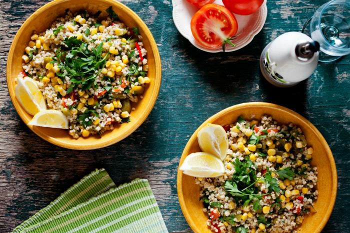 Piatto con risotto ed erbette, limone tagliato a meta e pomodori