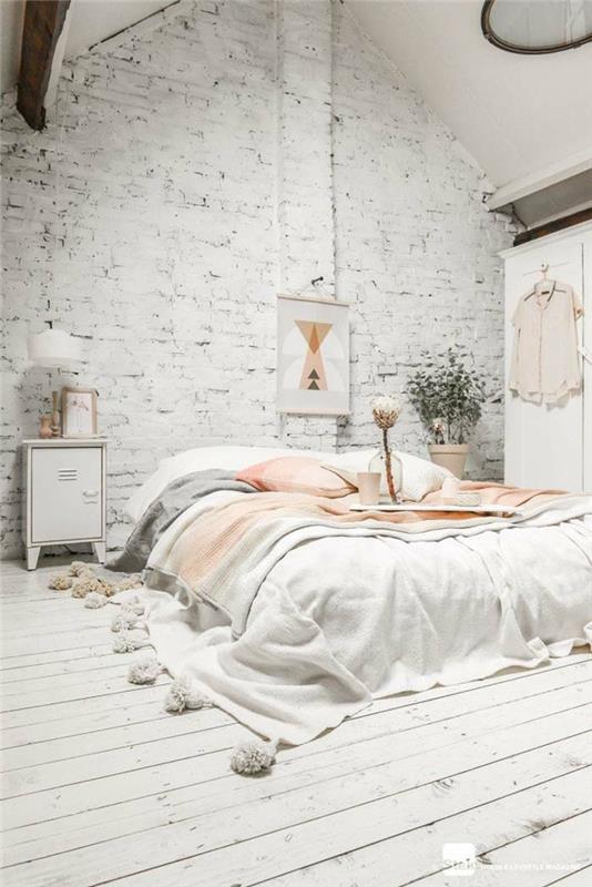 balta miegamojo sienų spalva, plytų siena ir didelė kokoninė lova, lovos išmetimas su pompomis, baltos grindys