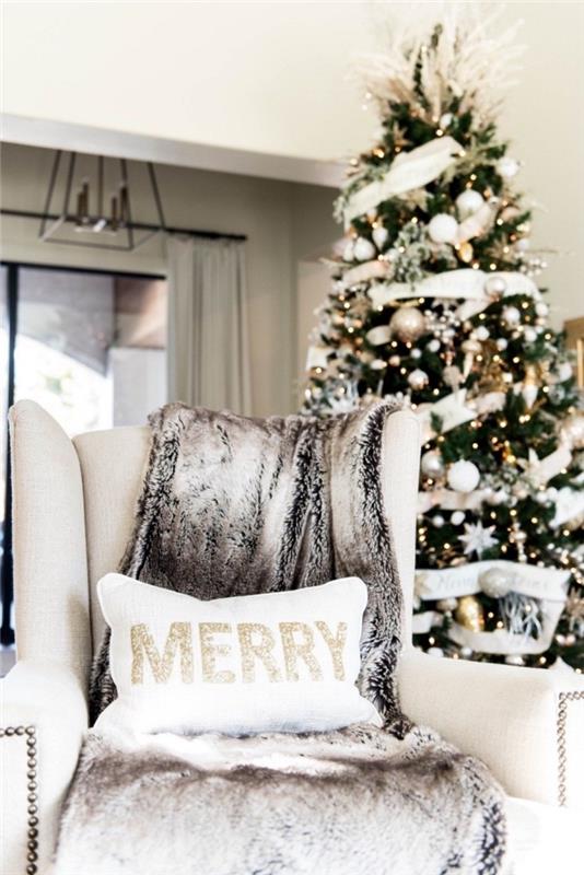 Beyaz ve altın renginde Noel ağacı süsleme fikri, bej kumaş koltuk ve suni kürk ekose ile döşenmiş koza dinlenme köşesi