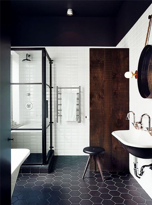 vintage classy design kopalniški dekor s črnimi keramičnimi tlemi in belo steno s črno tuš kabino ter kmečko steno iz temnega lesa in retro umivalnikom