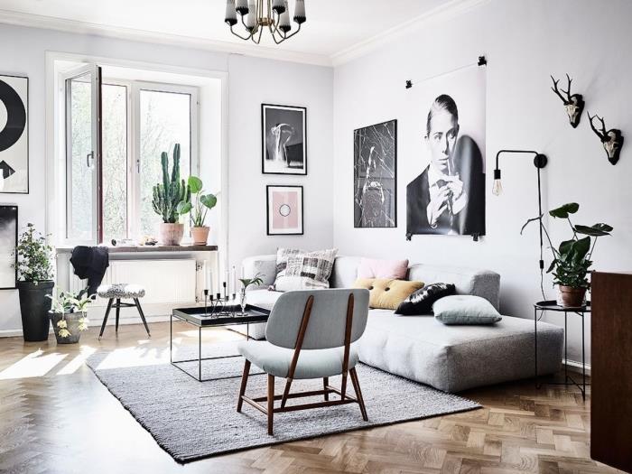 geniş formatta siyah beyaz fotoğraf posterlerinden oluşan orijinal çerçevelerden oluşan bir duvara sahip koza bir İskandinav oturma odasında modern bir atmosfer