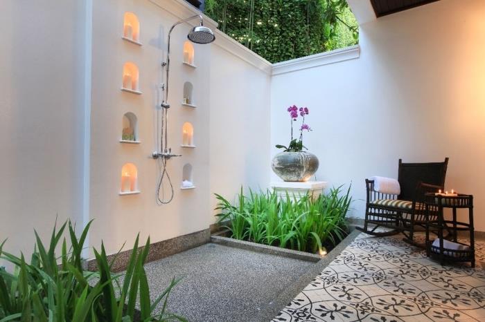 Paslanmaz çelik yağmur duşu ve siyah dokuma ahşap bahçe mobilyaları ile bahçede Zen banyo modeli