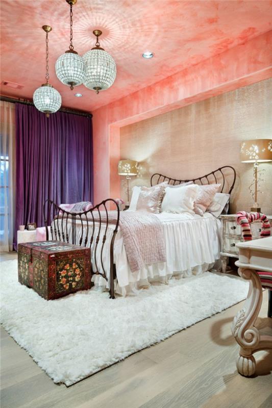 ideja za dekoracijo spalnice, mehka bela preproga, okvir postelje iz kovanega železa, koralni strop, pastelno roza blazine