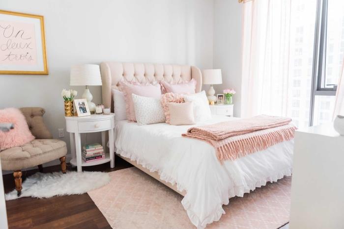 baltas miegamasis su tamsaus medžio parketu, dideliu rožiniu milteliniu kilimu ir mažu baltu gyvūnų odos kilimėliu