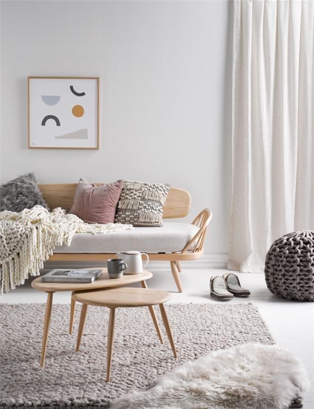 Skandinaviško vintažinio gyvenamojo kambario dekoras su natūralaus medžio akcentais su unikalaus dizaino sofa, pagardinta megzta antklode ir kokonuojančiu dirbtiniu kailiu bei kutais puoštomis pagalvėmis.