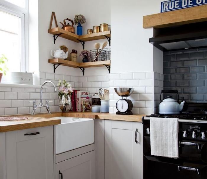 kaip sutvarkyti senovinę l formos virtuvę su pilkais virtuvės fasadais, mediniais stalviršiais ir medinėmis kampinėmis lentynomis, senovine virykle