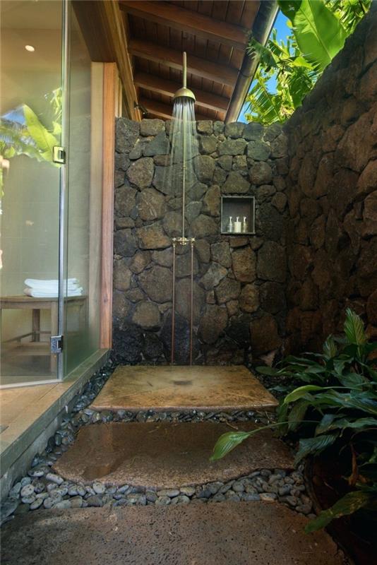 taş duvarlar ve taş duş teknesi ile bahçede küçük bir Zen banyo modeli
