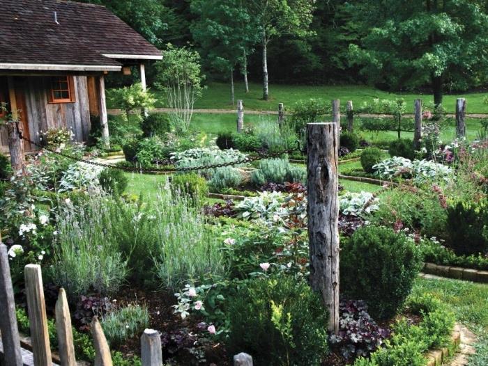 puiki idėja sodas, veja, daržovių lopinėlis, gėlių lova, tvora su mediniais stulpais ir grandinėmis, gėlių sodas su keliais krūmais ir gėlėmis, kaimo namas, pastoracinė aplinka