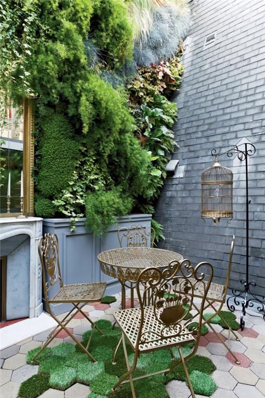 navdih za okrasitev terase ali vrta z bujno zeleno steno in starinskim kovinskim vrtnim pohištvom, ki na vrt prinaša pridih domišljije