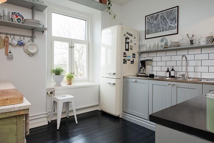 boy dolapları, bu beyaz ve gri mutfağa rustik bir görünüm kazandıran açık bir duvar rafı ile değiştirilmiştir.