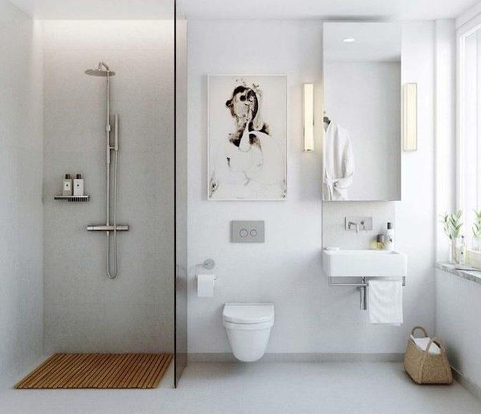 kopalnica odprtega tipa z ločeno kabino za prhanje, visečim wc-jem in belimi stenami betonsko siva tla v sodobnem minimalističnem skandinavskem slogu