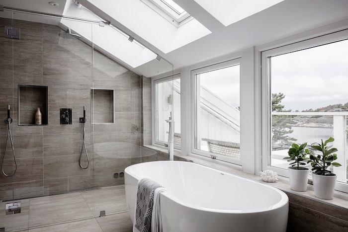 Model podstrešne kopalnice pod svetlo streho z okni in strešnim oknom s popločanim italijanskim tušem in ovalno samostoječo kadjo