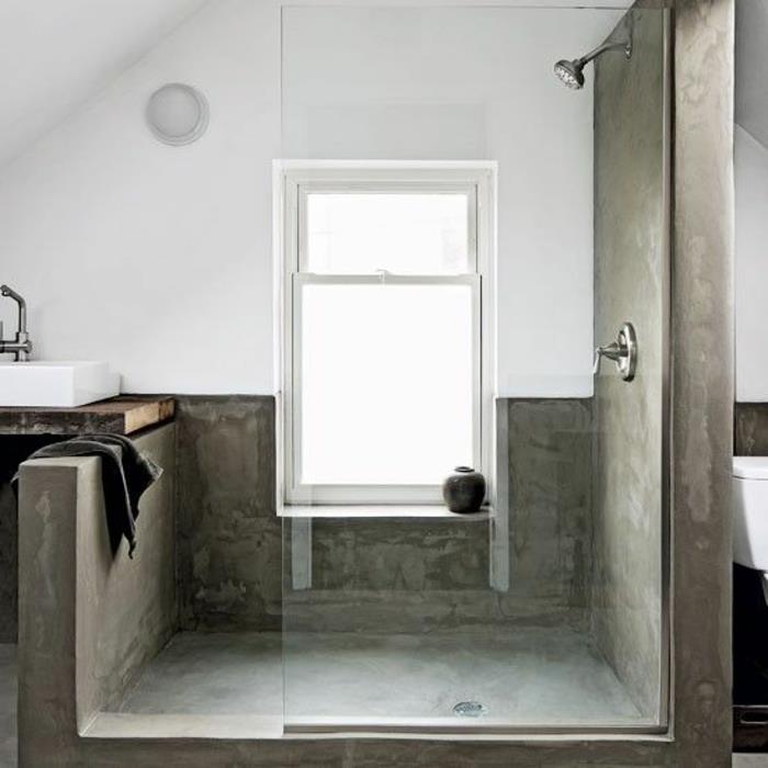 majhna kopalnica-pod naklonom-z-betonskimi-stenami-in-sivimi tlemi